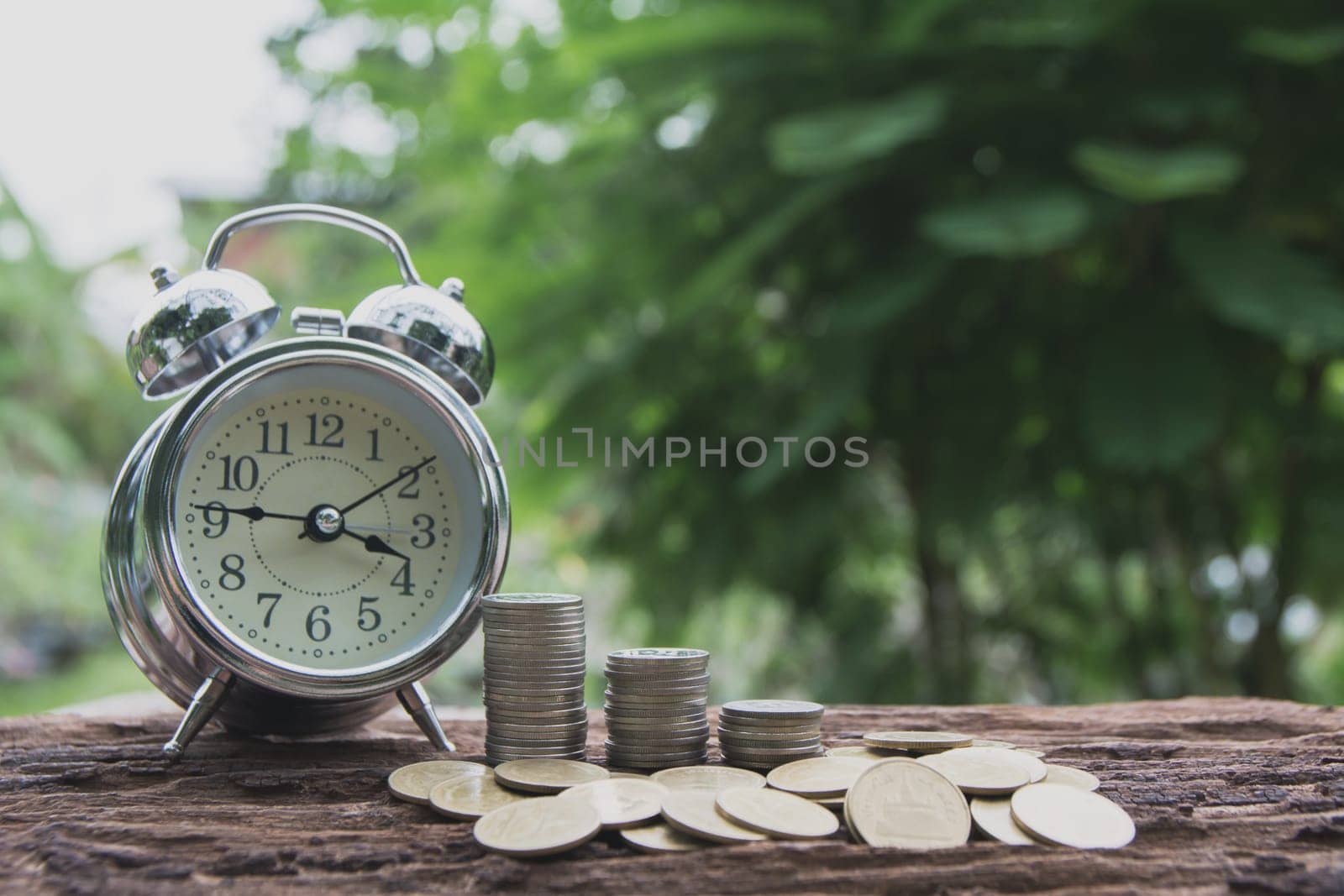 Saving money concept with money coin stack growing for business and alarm clock. financial and accounting concept.