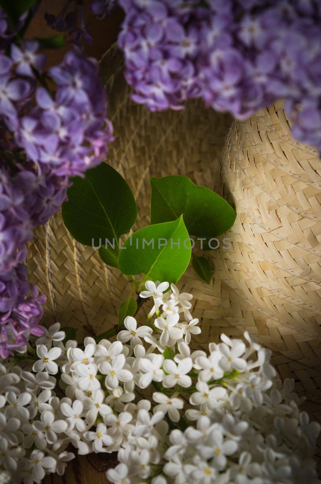 Still-life with a bouquet of lilacs and a straw hat, close-up
