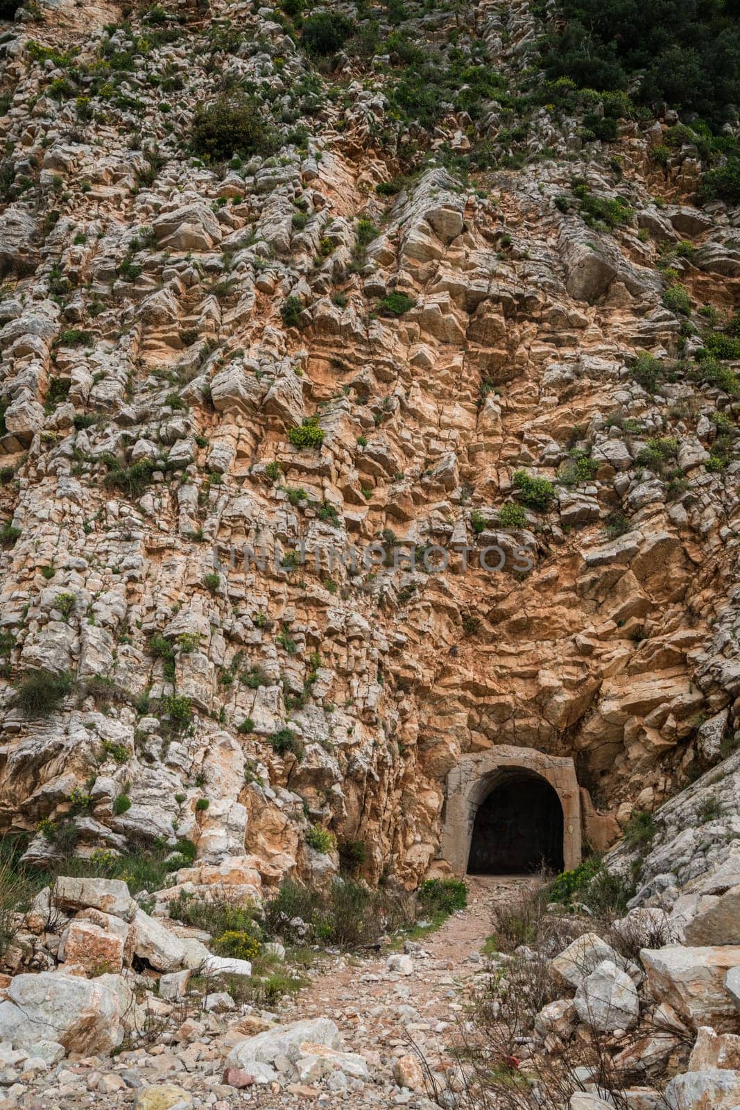 Entrance to the tunnel cut out inside the rock on the coastal walking path in Petrovac, Montenegro