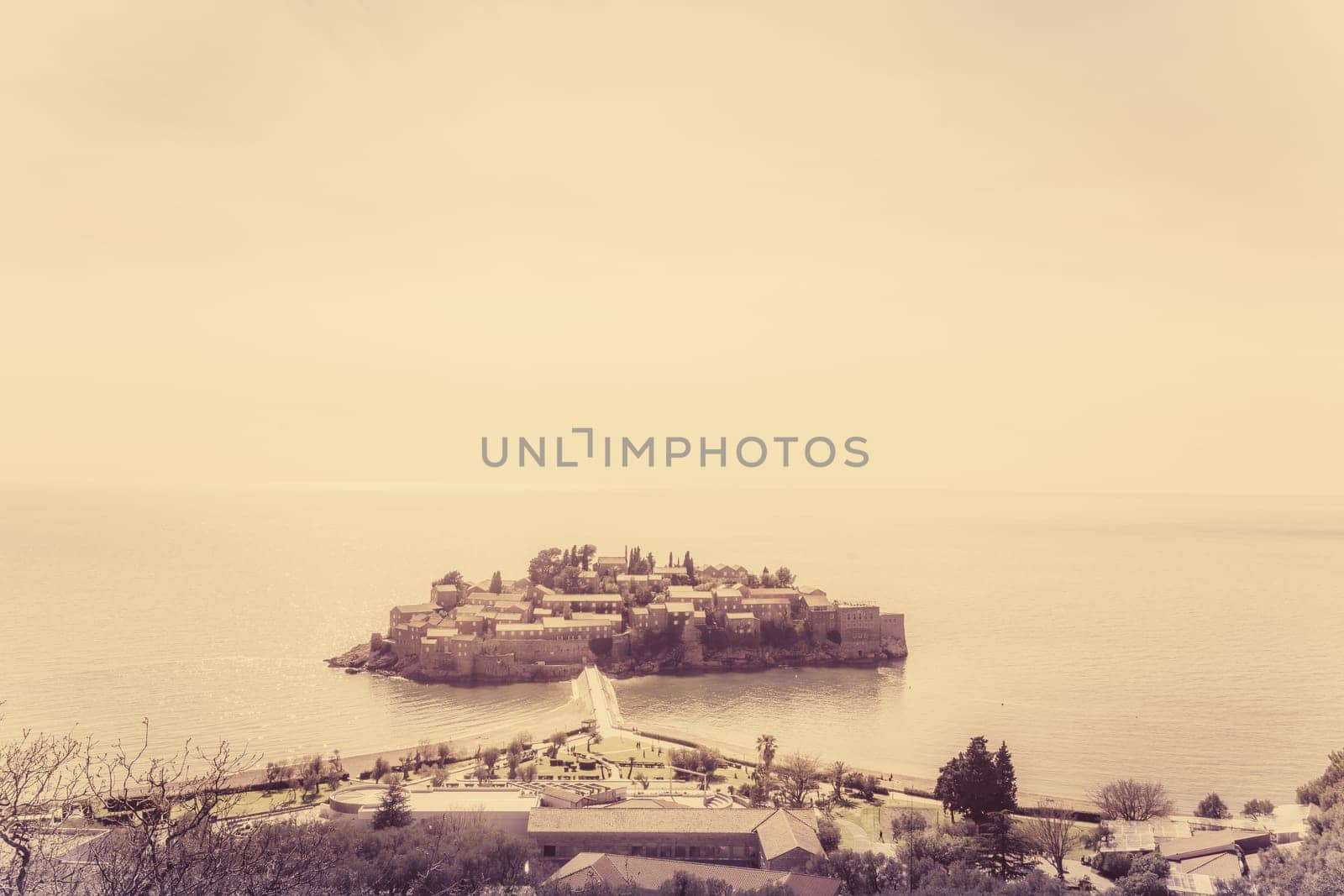 Retro sepia vintage image of the historical Sveti Stefan old town, landmark on the coast of Montenegro