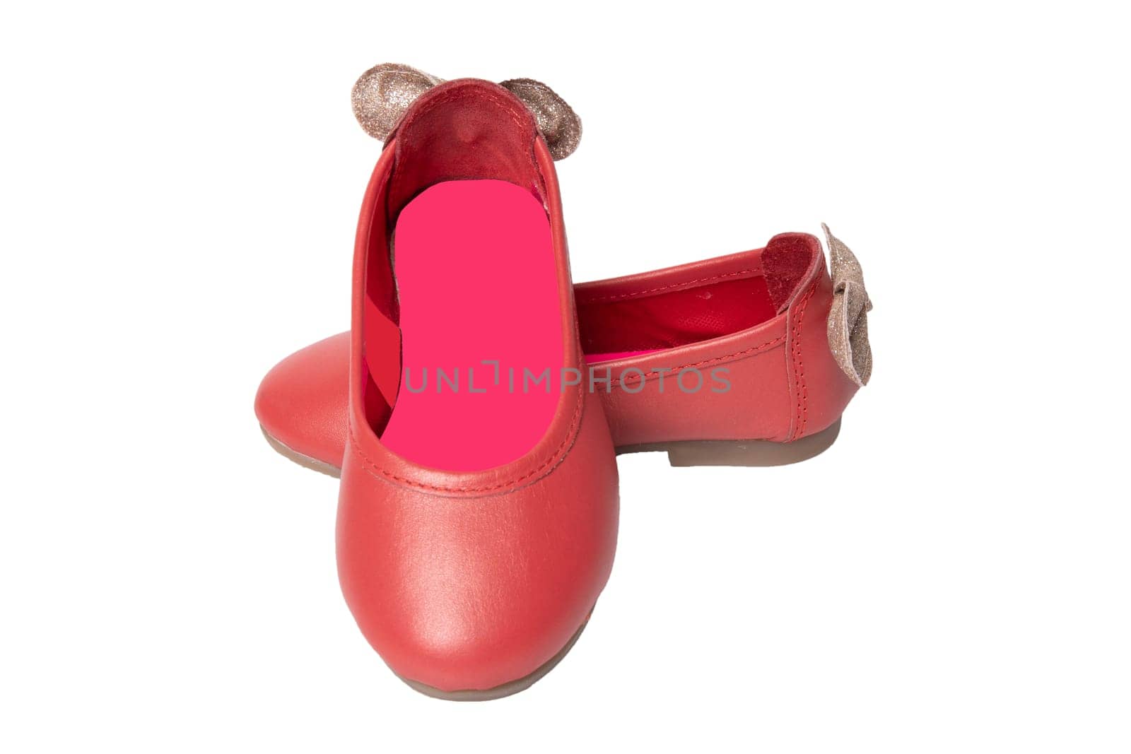 Red shoes. Closeup of red girls shoes with a golden bow isolated on a white background. Fashionable footwear.