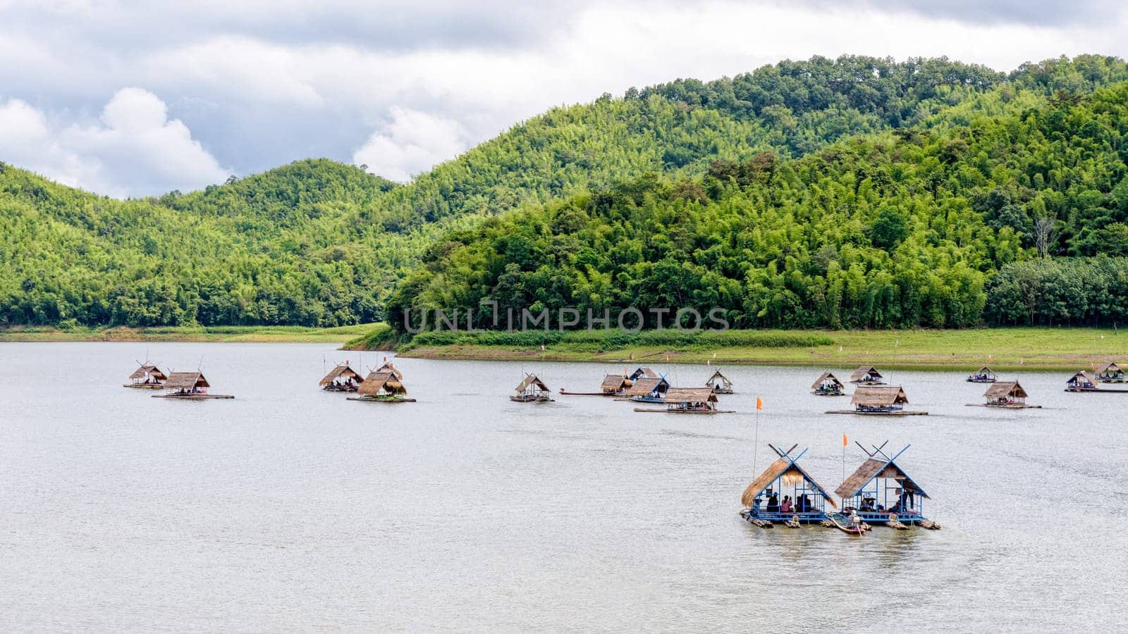 Bamboo raft shelter are floating restaurant in the middle of water under the blue sky as a tourist attraction at Huai Krathing Reservoir, Loei province, Thailand, 16:9 widescreen