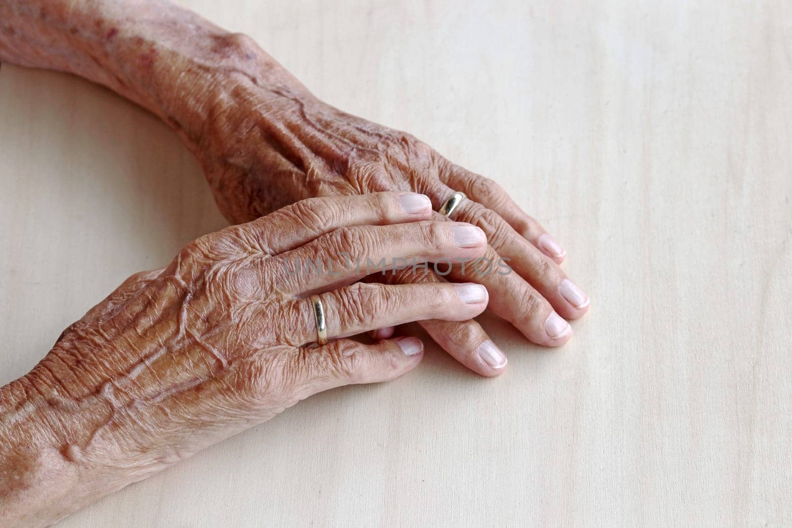The hands of a very old woman. Old woman's hands on a table. Old woman's hands with veins
