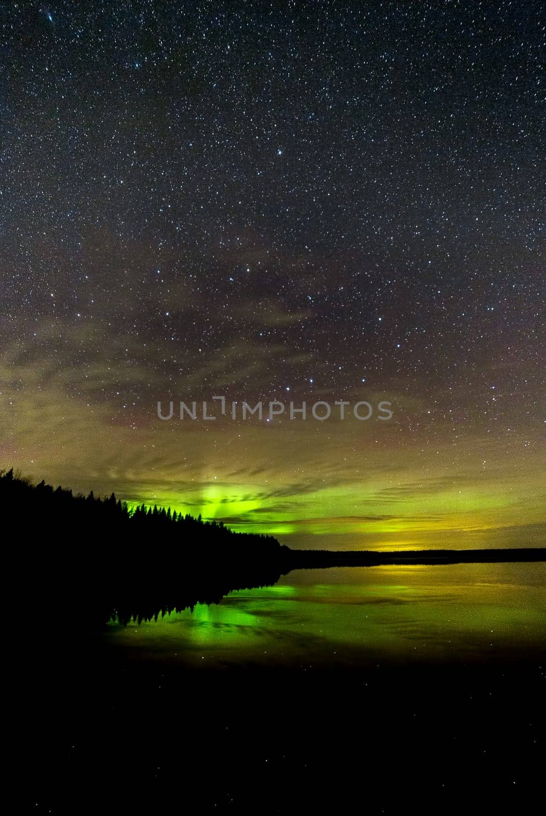 Northern Lights over Lake with clouds and stars.
