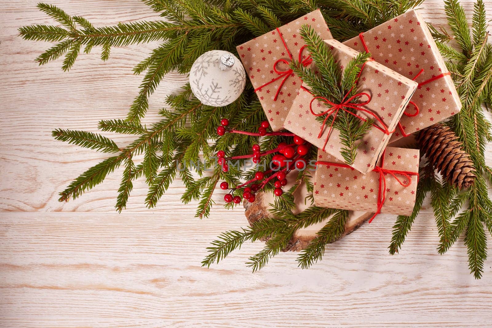 Still life with gift boxes, fir tree branches and christmas decorations on a wooden background.Top view with copy space. Christmas and New Year