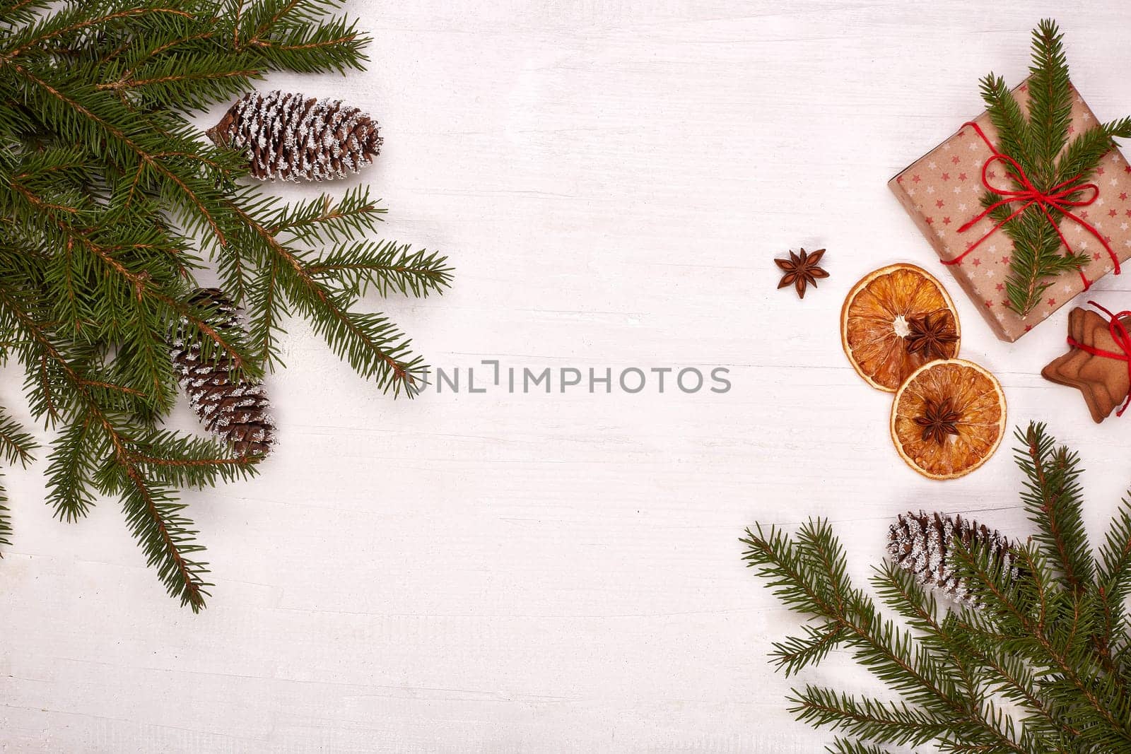 Fir branches, cones and gift boxes on a white wooden background. Top view with copy space. New Year and Christmas