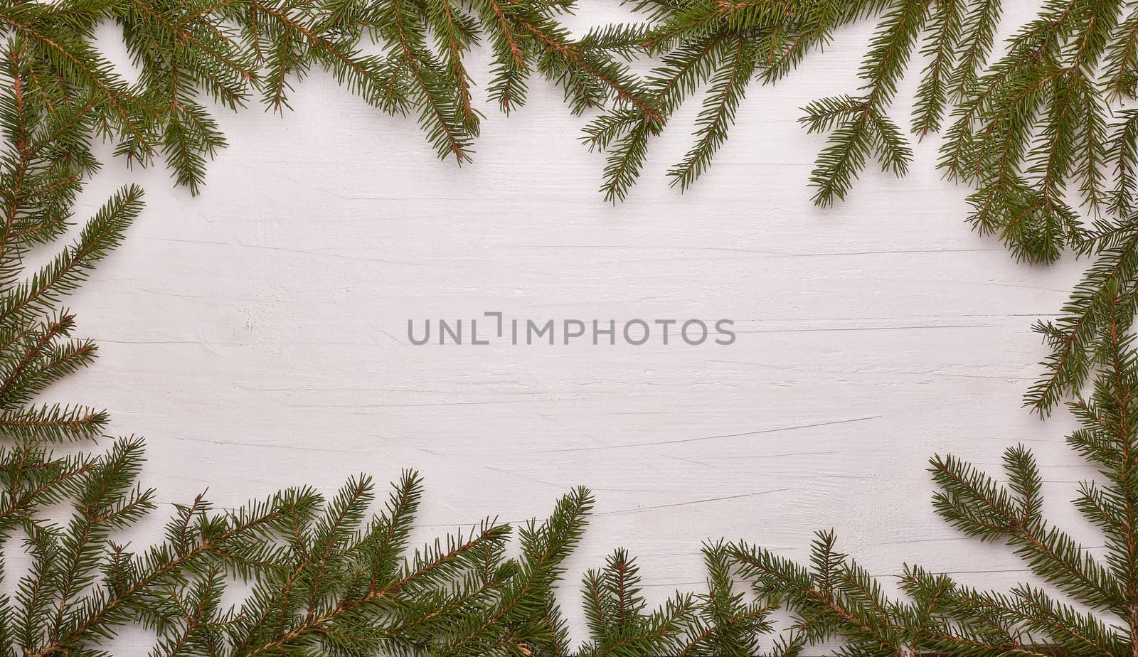 White wooden background with frame from fir branches. New Year and Christmas