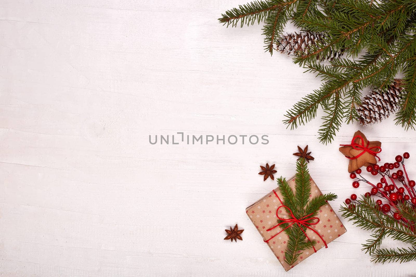 Fir branches, cones and gift boxes on a white wooden background. Top view with copy space. New Year and Christmas