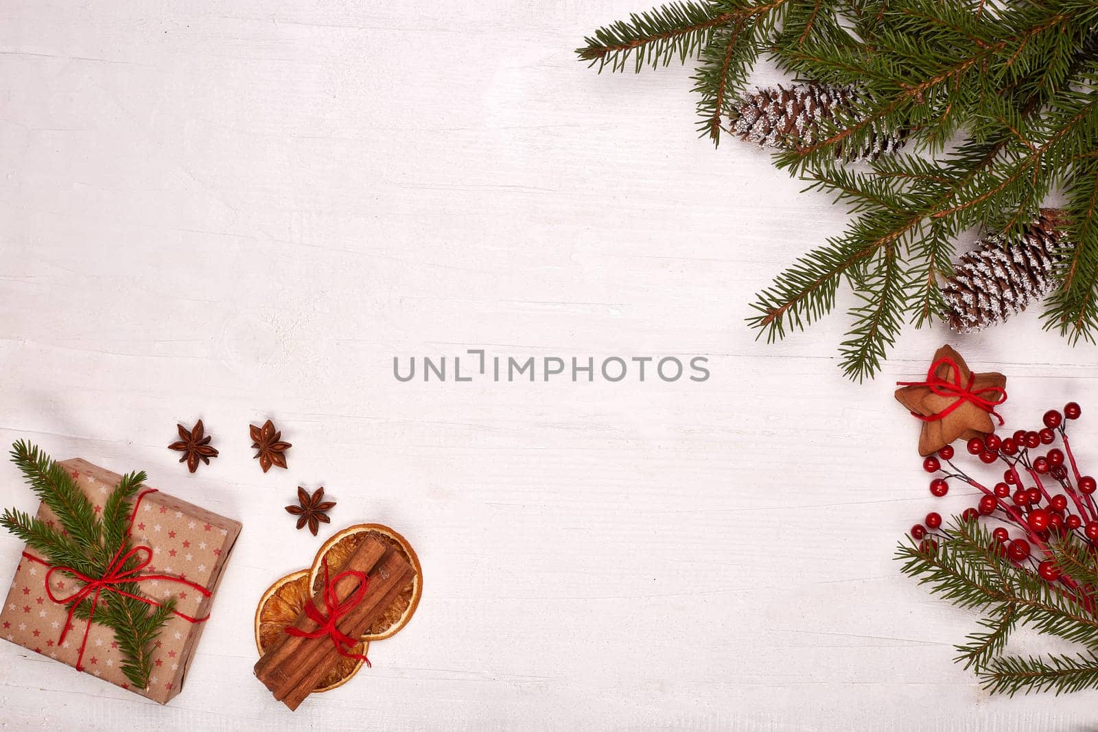 Fir branches, cones and gift boxes on a white wooden background. Top view with copy space. New Year and Christmas