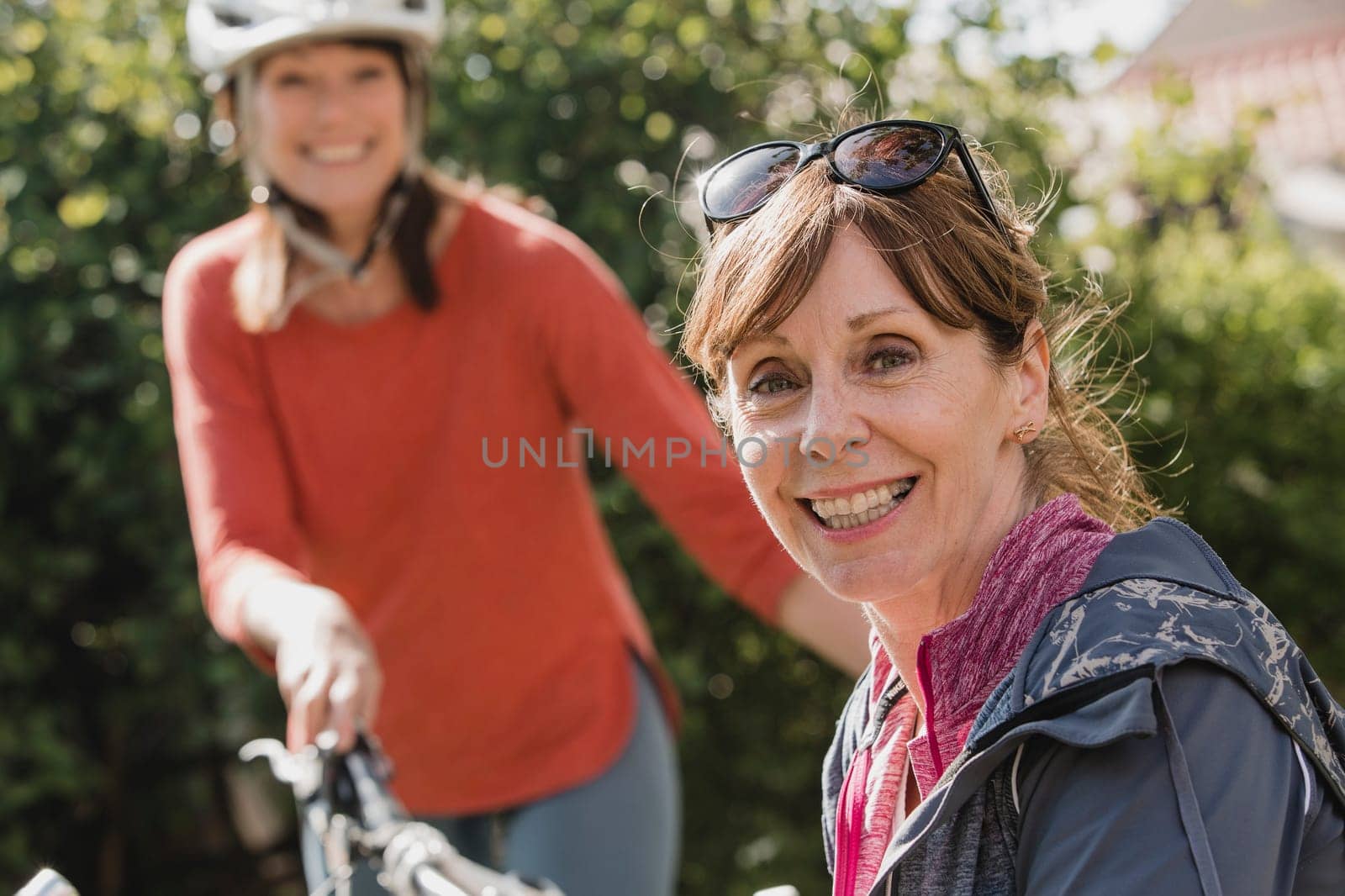 Headshot of a senior female cyclist looking at the camera and smiling.