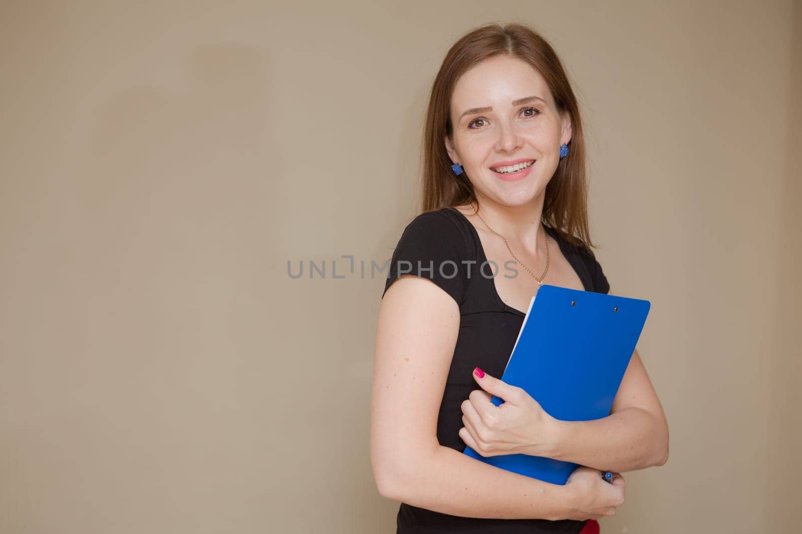 Happy beautiful business woman with clipboard in the office.