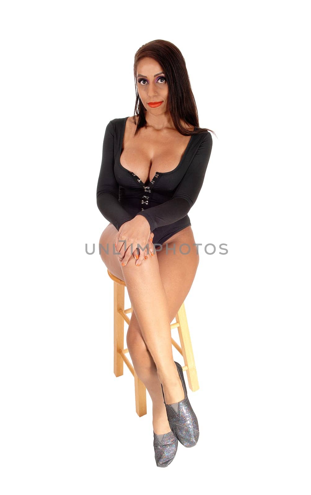 A young beautiful slim woman sitting in a black body suit on a chair. with black hair and big breasts, isolated for white background.