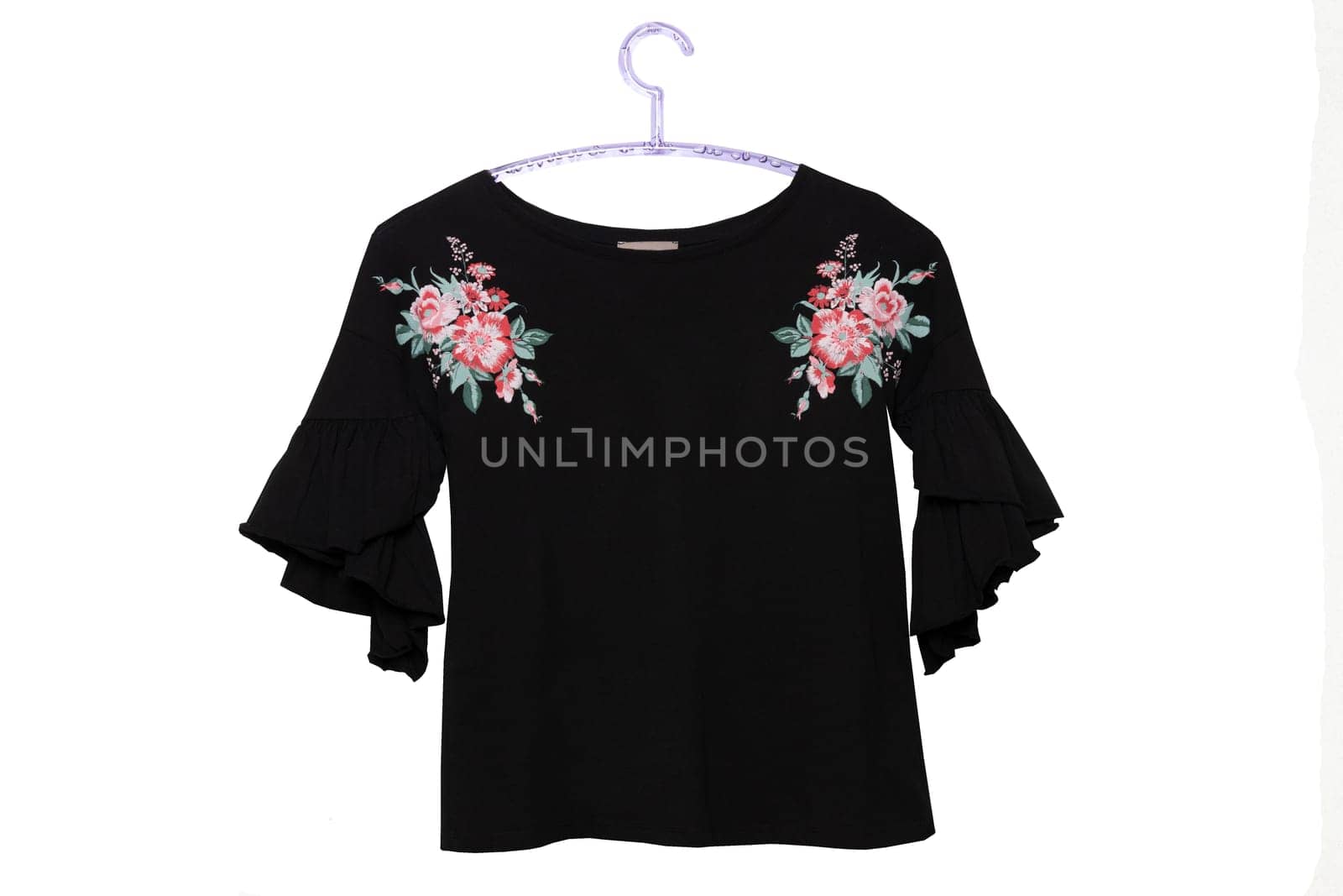 Black womans clothing. A female black summer shirt or blouse with a floral print on hanger isolated on a white background. Summer fashion.