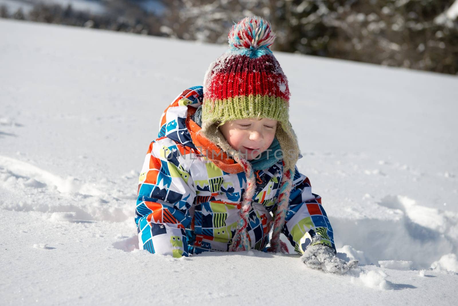 little 3 year old child playing in the snow