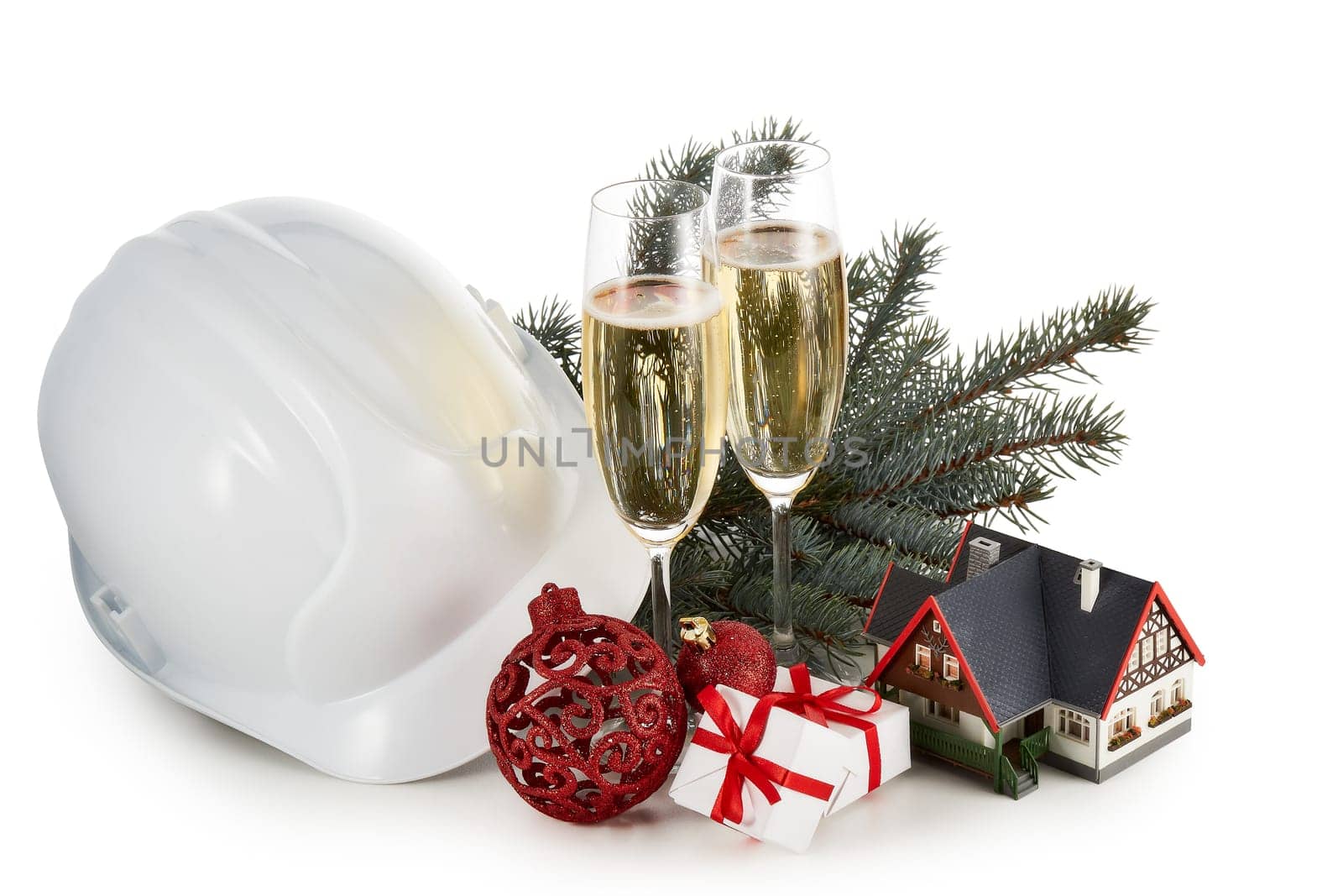 Construction hard hat, fir tree branches, model house, two glasses with champange and Christmas ornament isolated on a white background. New Year and Christmas. Horizontal view