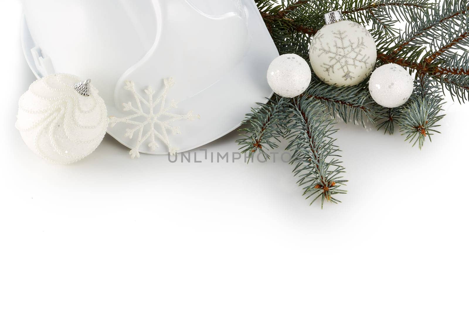 Construction hard hat, fir tree branches and Christmas ornament isolated on a white background. New Year and Christmas. Top view with copy space
