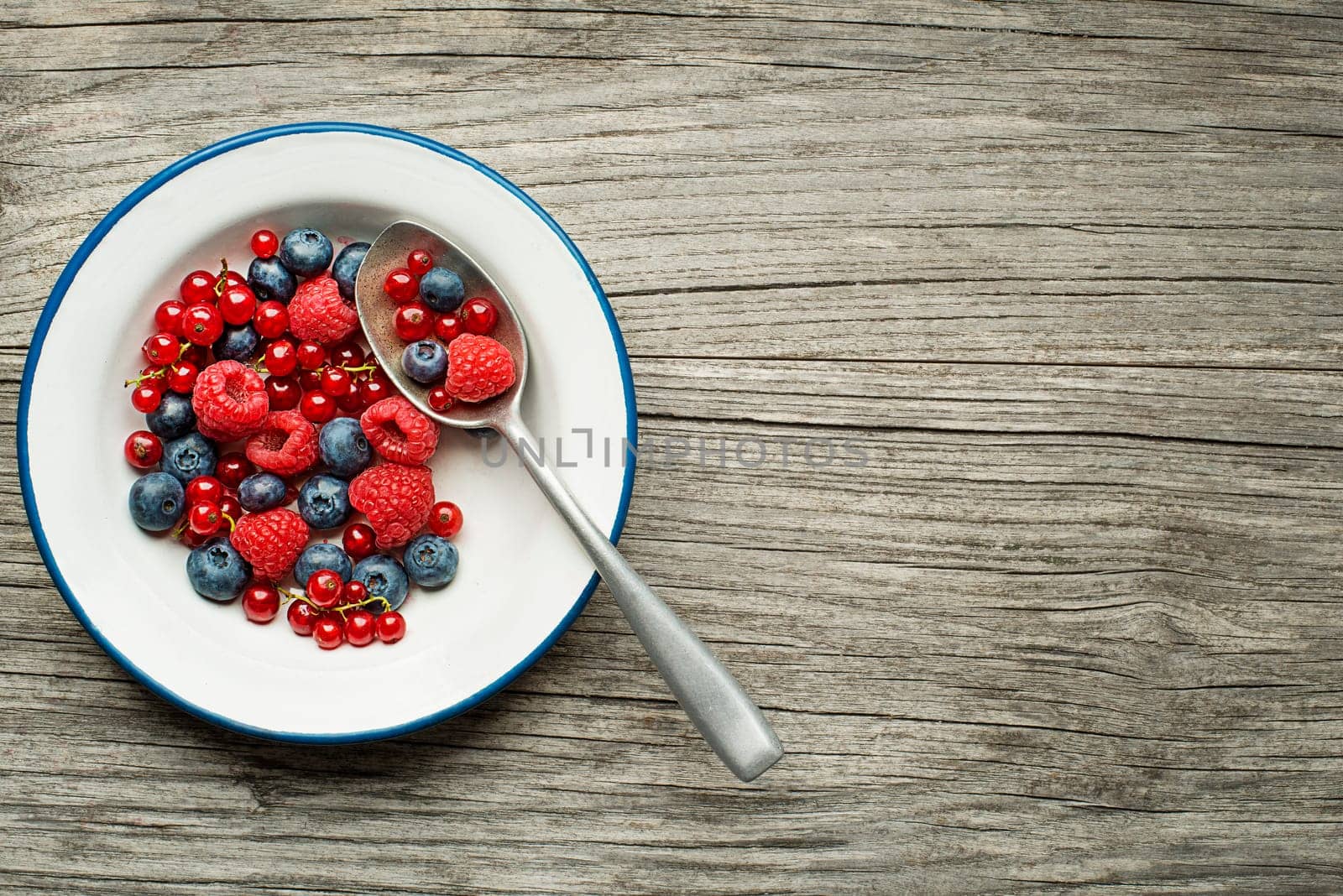 Healthy snack with fresh berries in a bowl on wooden background