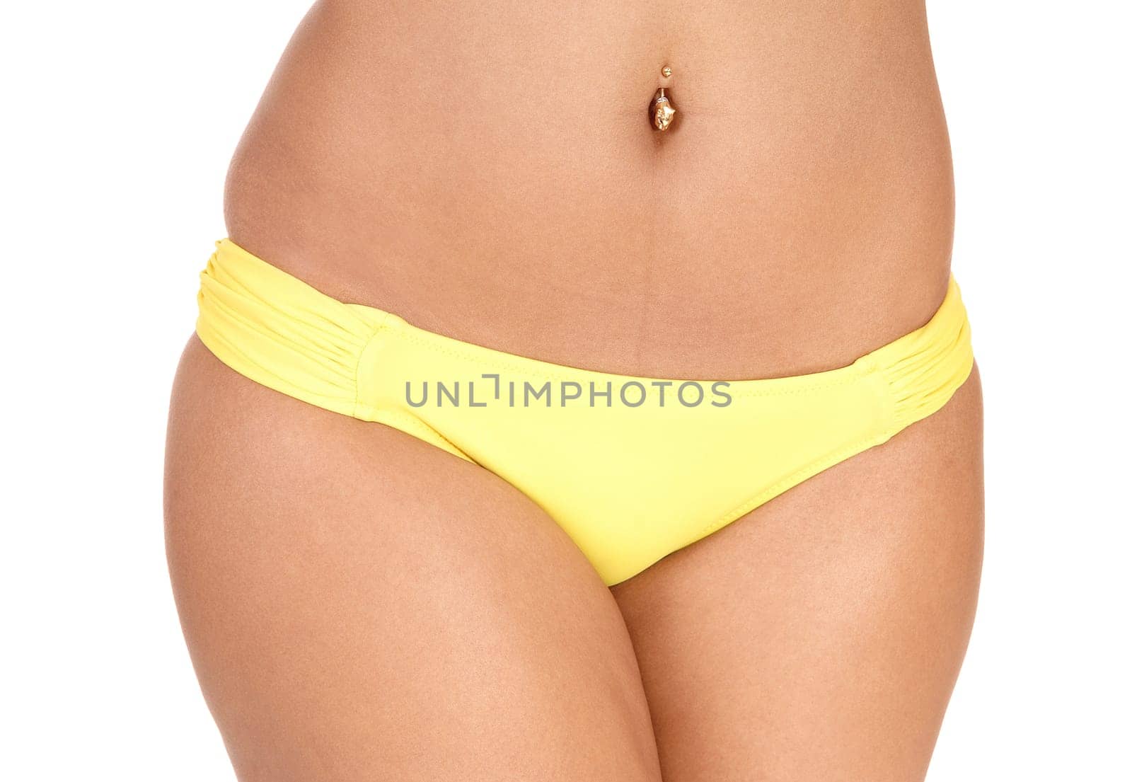 The middle section of slim young woman wearing a yellow bikini bottom.with some jewellery in her belly bottom, isolated for white background.