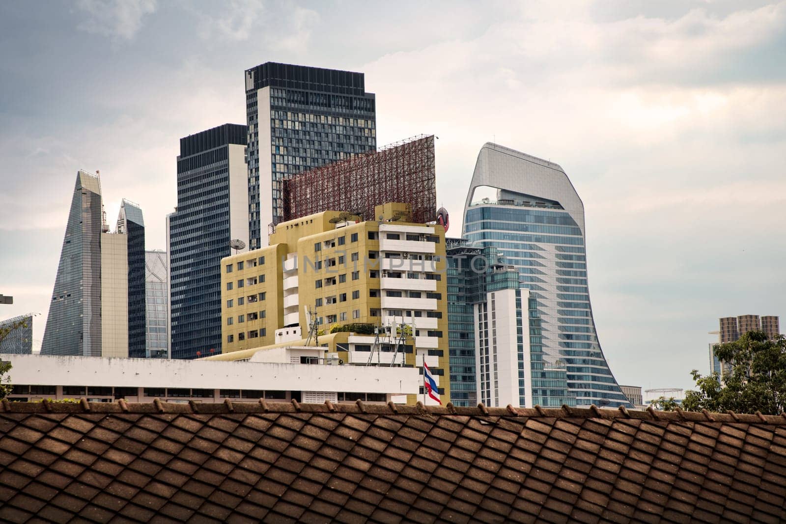cityscape of modern architecture buildings over moody sky in downtown Bangkok, Thailand