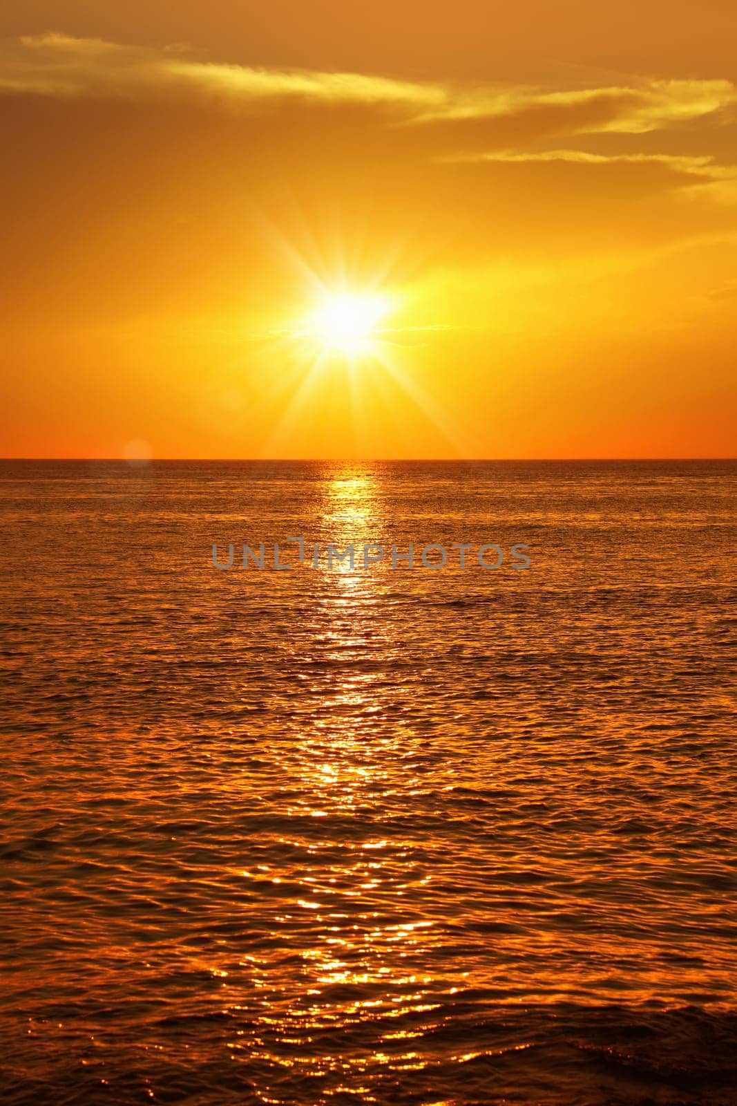 Colorful empty seascape with shiny sea over cloudy sky and sun during sunset in Cozumel, Mexico