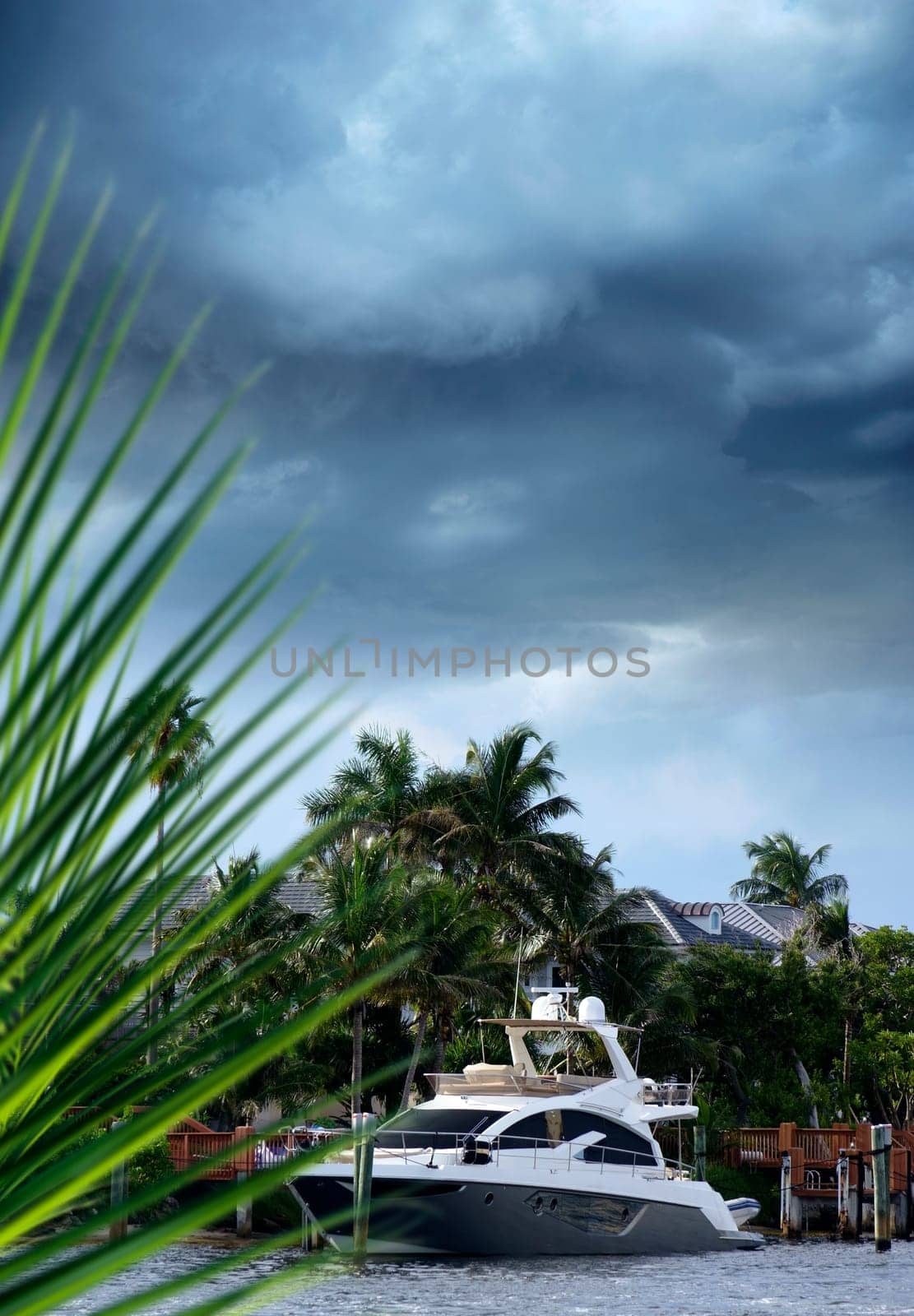 Close up parked boat at dock on canal over storm sky in Florida, USA