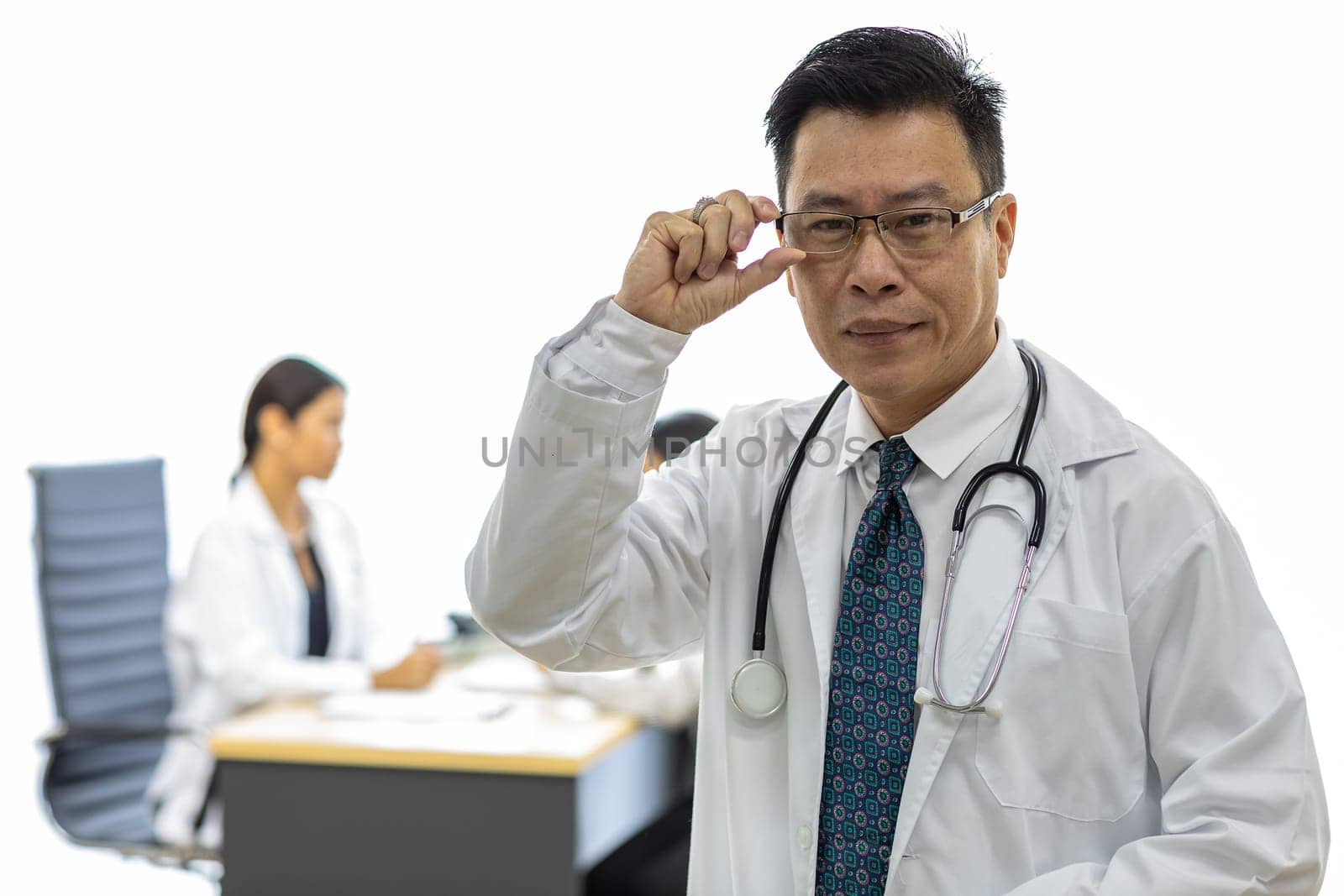 Portrait of senior Doctor in examination room medical office.