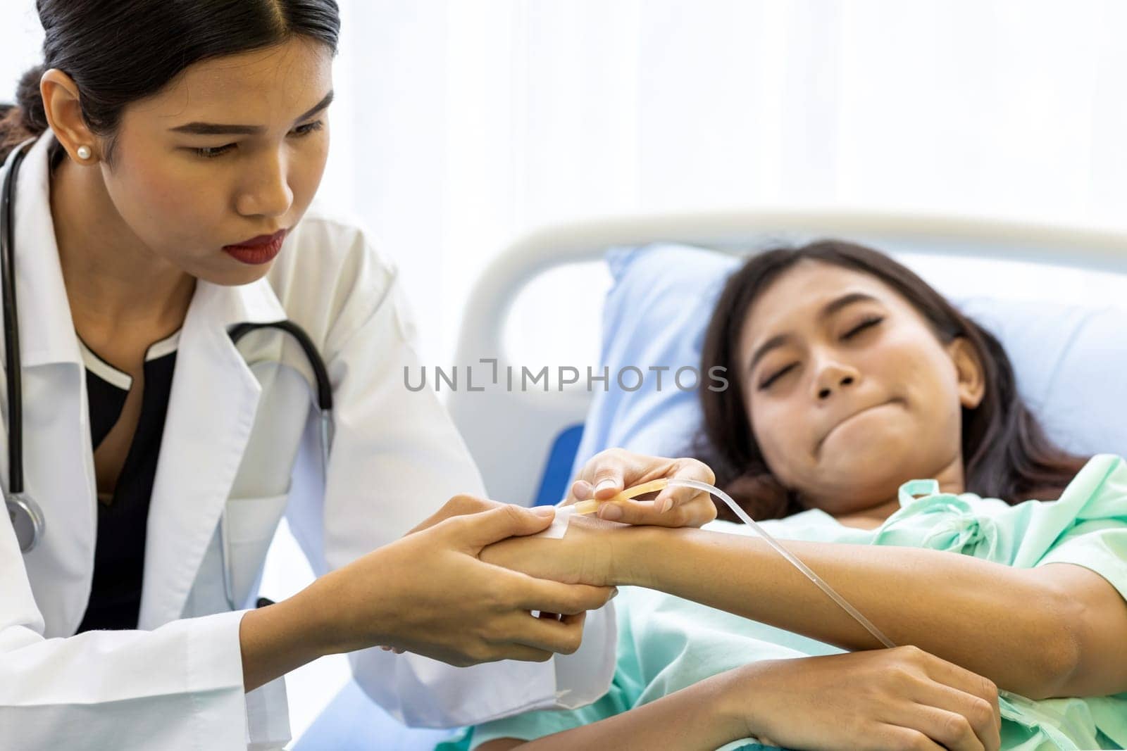 Female doctor preparing a saline tube for patient in the hospital.