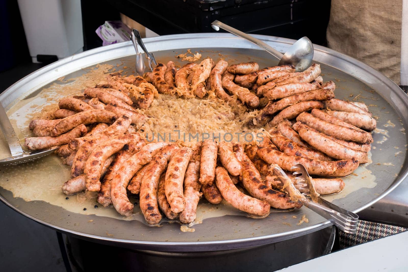Sausages and sauerkraut cooked in a large pan. Street food