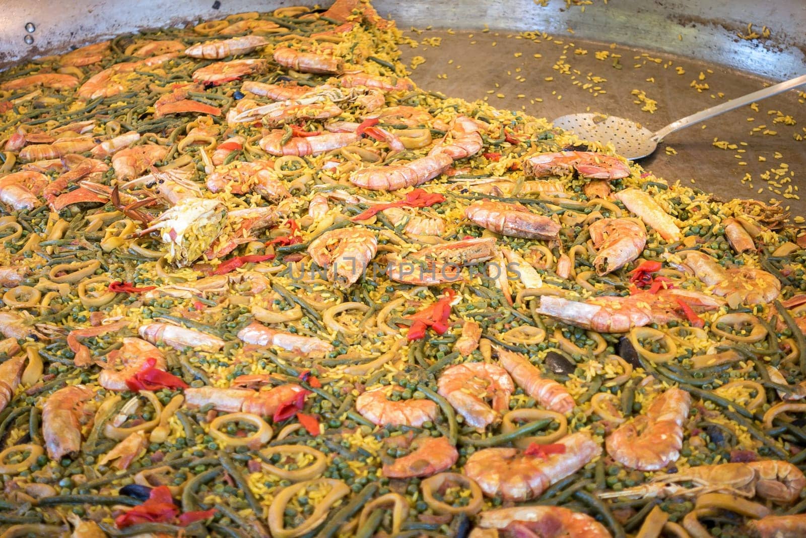 Large pan of paella in a street tray with food