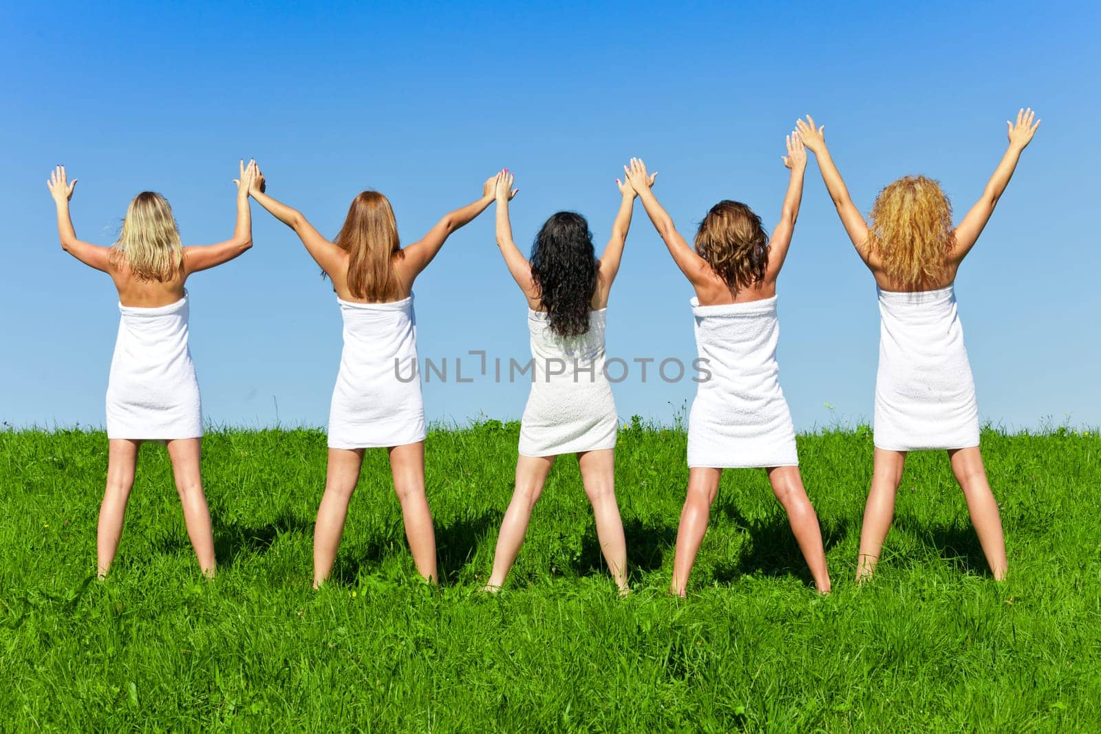 Woman group in towel on the summer meadow