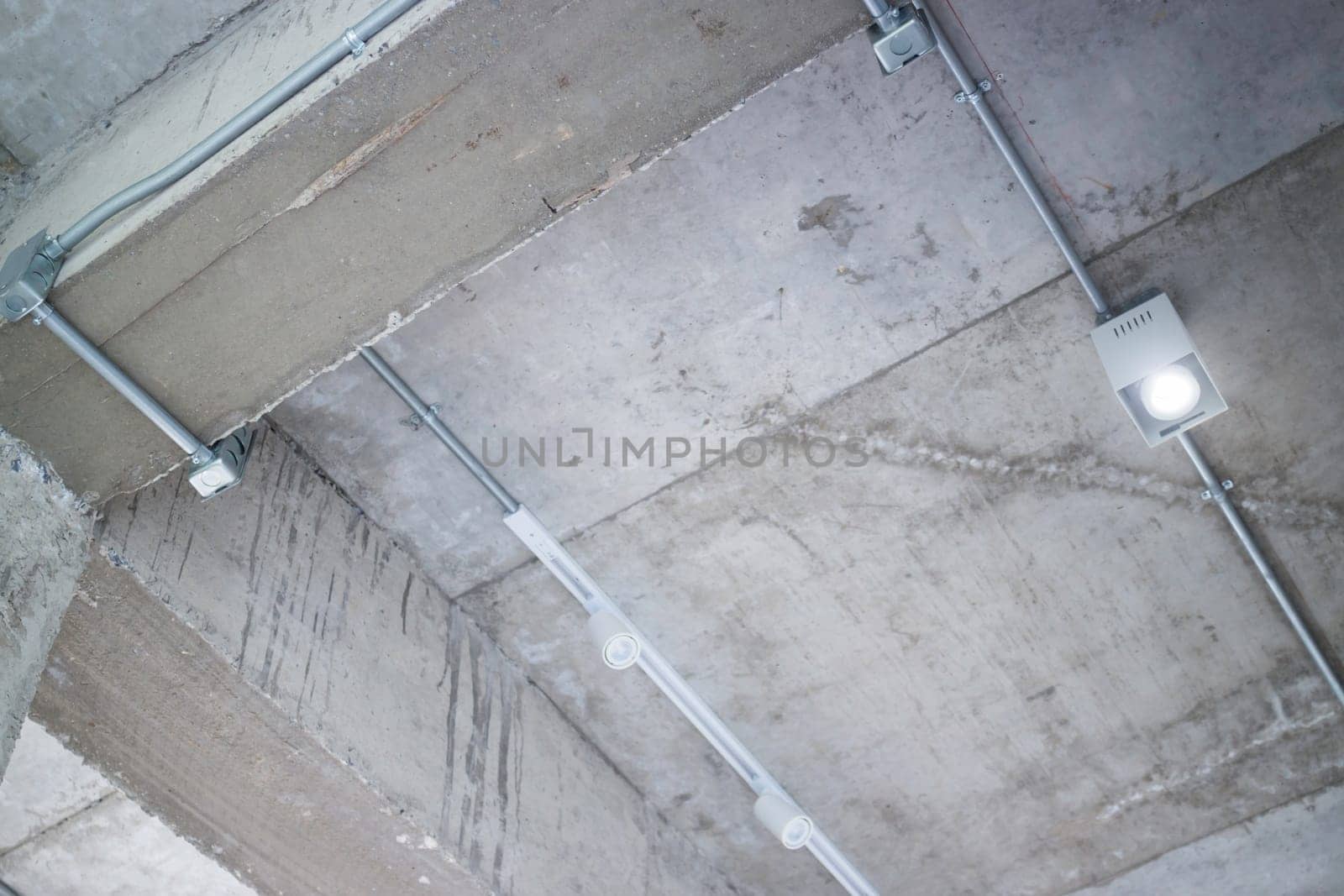 Ceiling metal pipe of electricity cable in building, stock photo