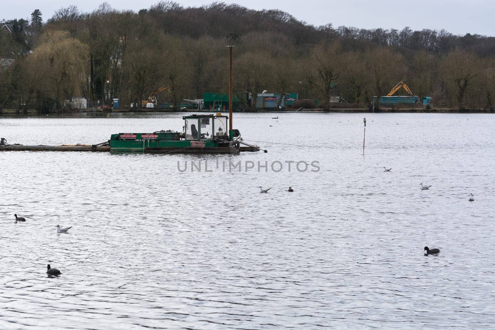 HEILIGENHAUS, NRW, DEUTSCHLAND - MÄRZ 03, 2017:.Special ship, working platform in use on a small pond. Wet dredging at the Abtskuecher Teich in Heiligenhaus.