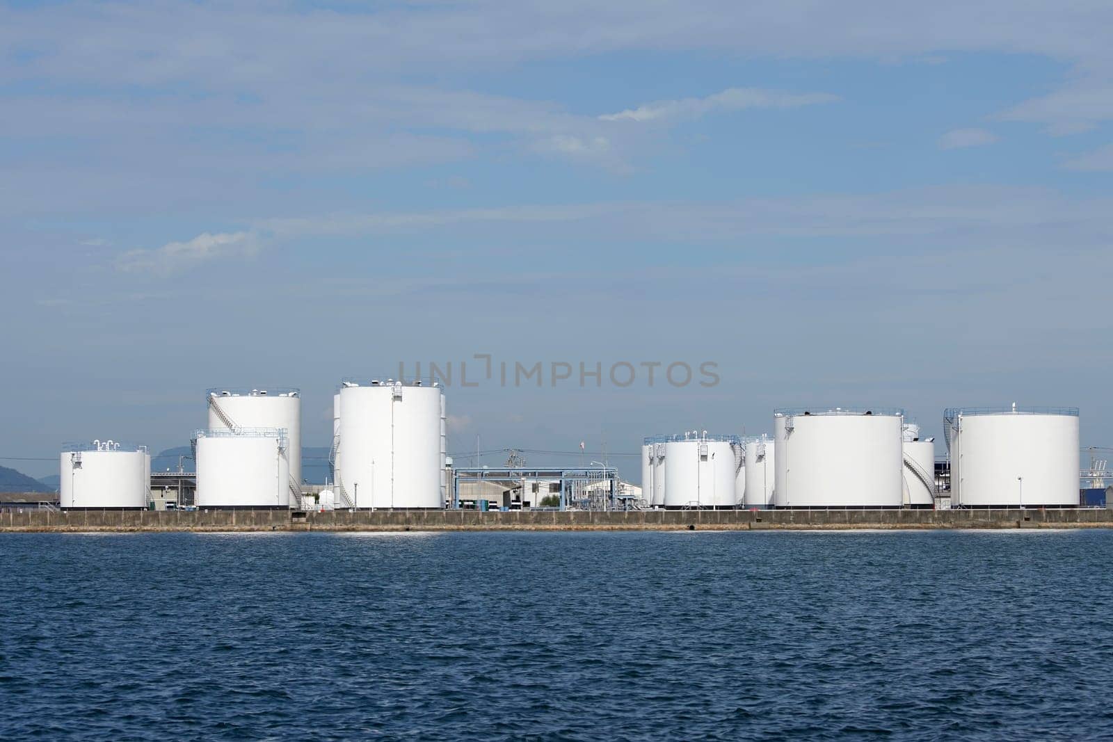 Industrial fuel storage tanks against the blue sky