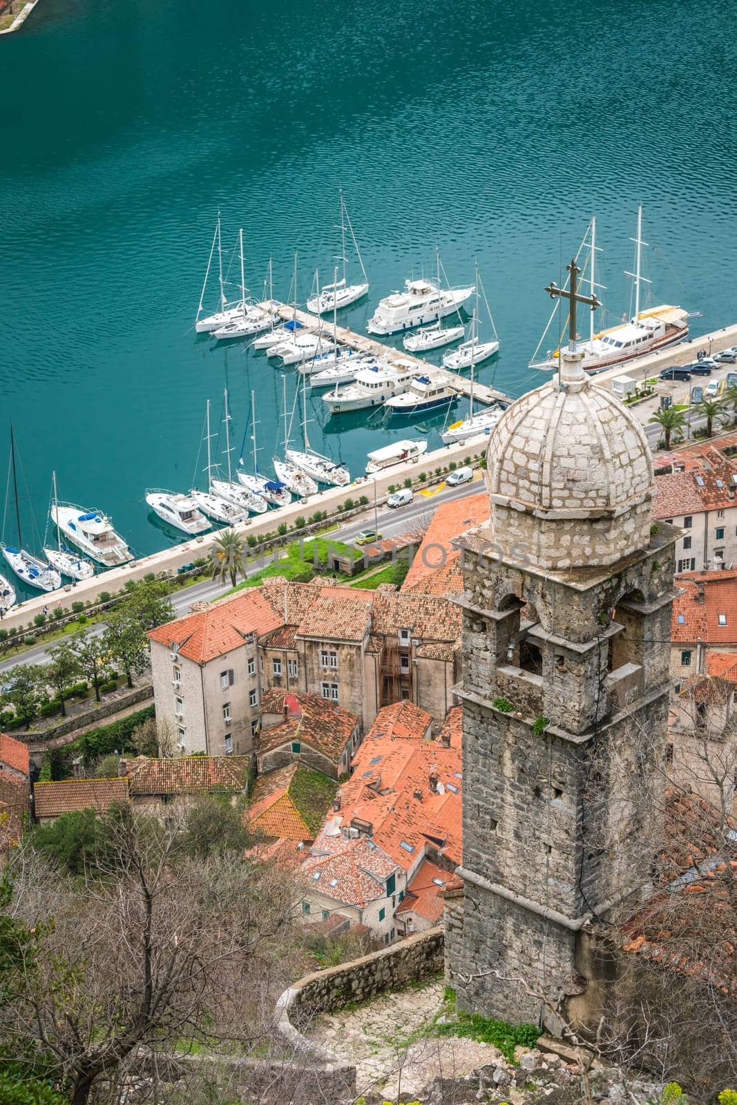The dome and bell tower of The Chapel of Our Lady of Salvation with Kotor Bay harbour and marina below, Montenegro