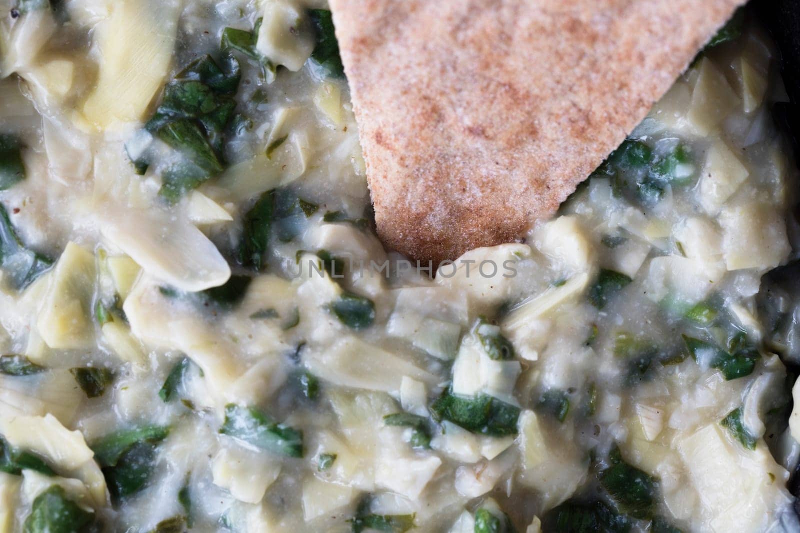 Close up of vegan spinach artichoke dip and whole wheat pita bread