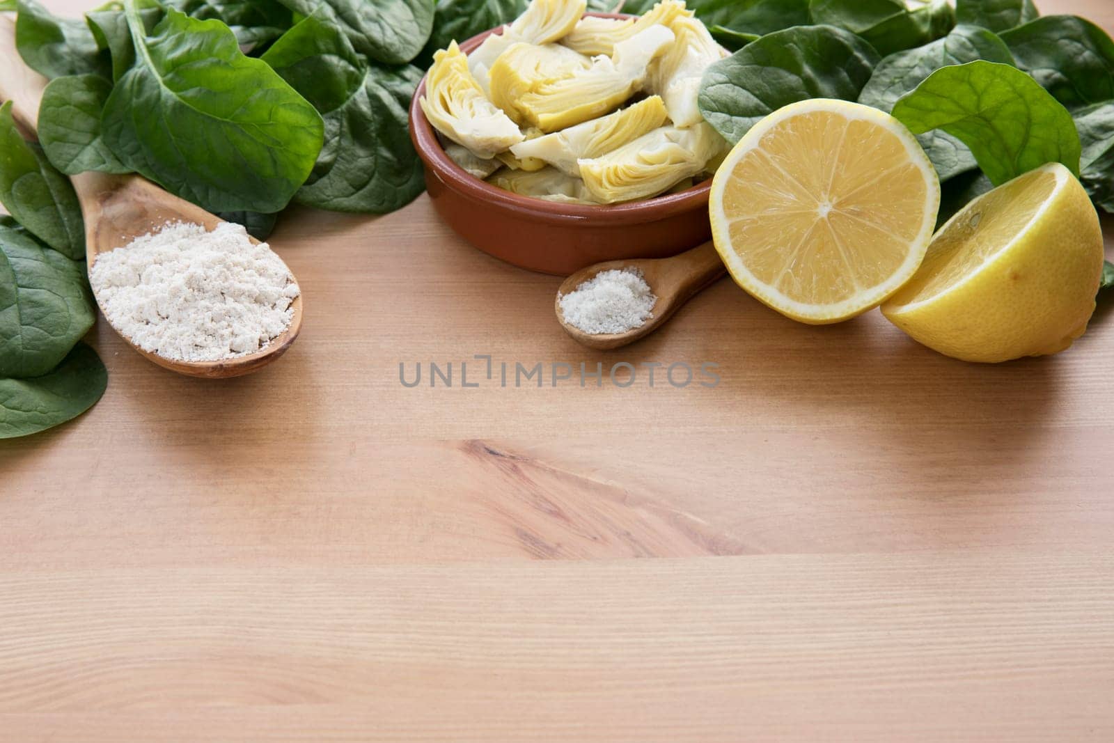 Artichoke hearts, spinach, lemon and other ingredients for vegan dip.