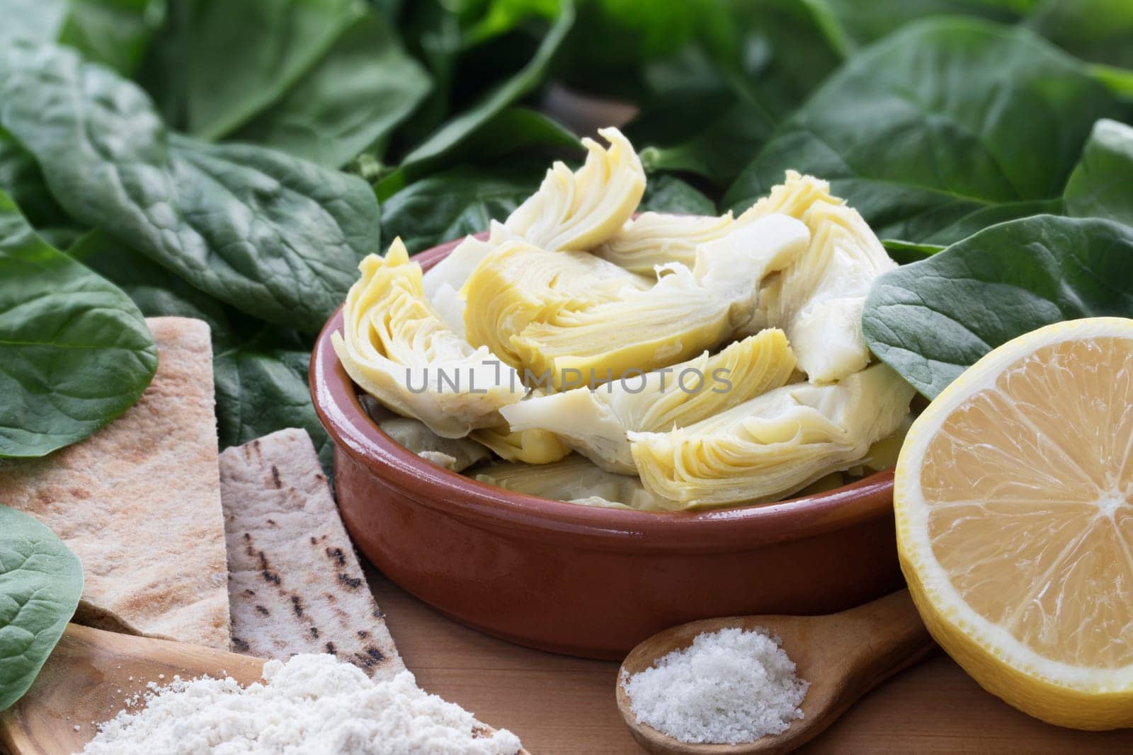Artichoke hearts, spinach, lemon and other ingredients for vegan dip.