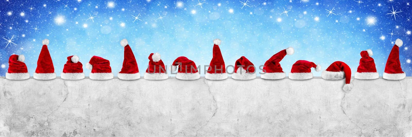 row of red white plush santa claus christmas xmas hat on  empty concrete wall billboard blue bokeh stars sky background