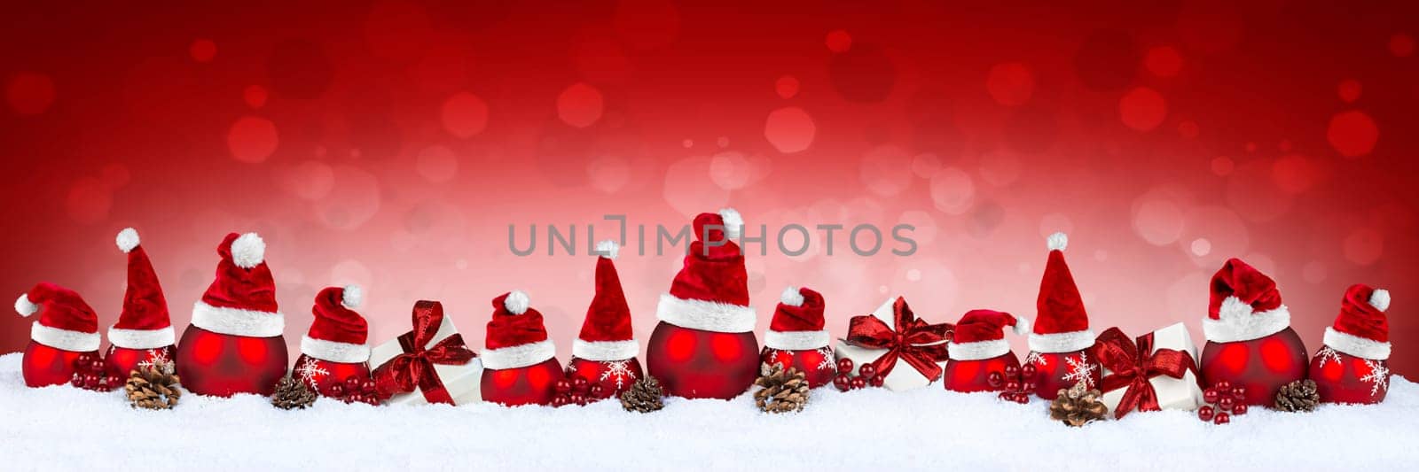 red christmas bauble ball row with white xmas present gift boxes pine cones and santa hats on bokeh background