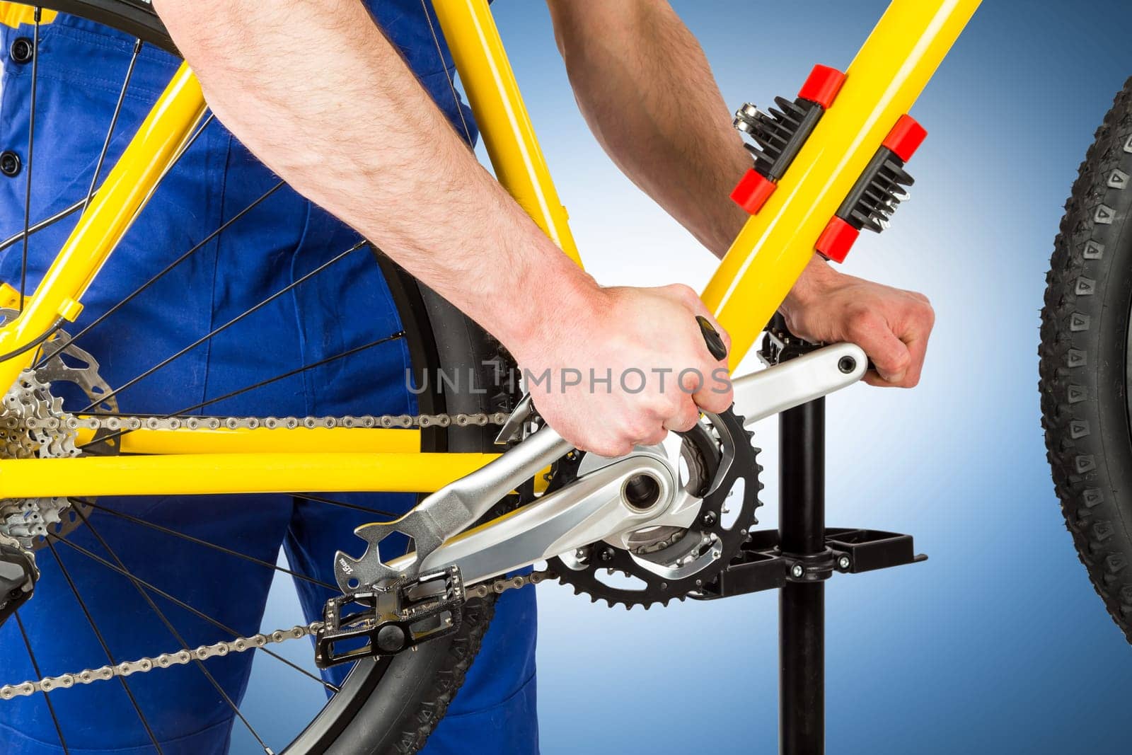bicycle mechanic tightening pedal on mountain bike