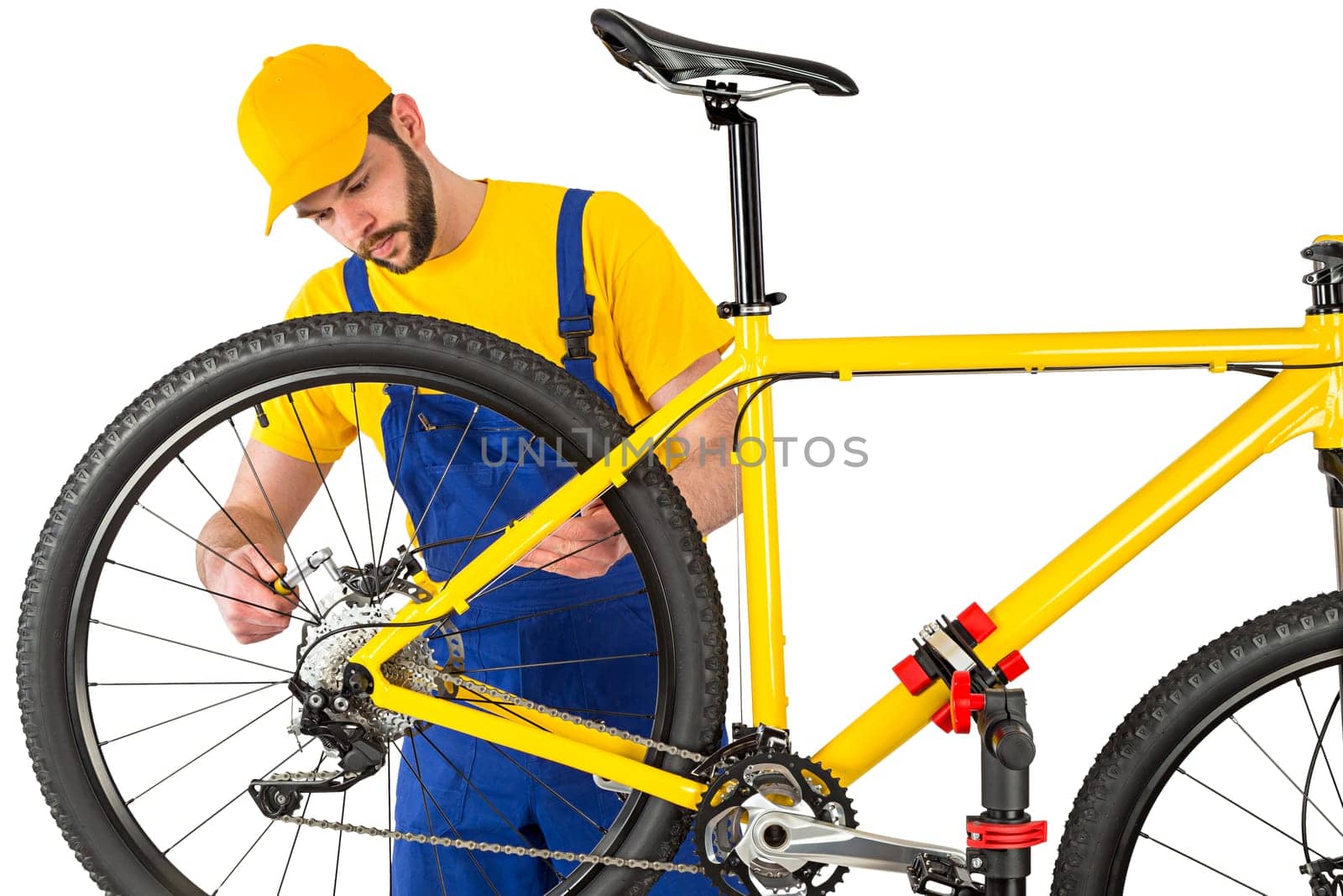 bicycle mechanic mounting brake caliper on yellow mountain bike