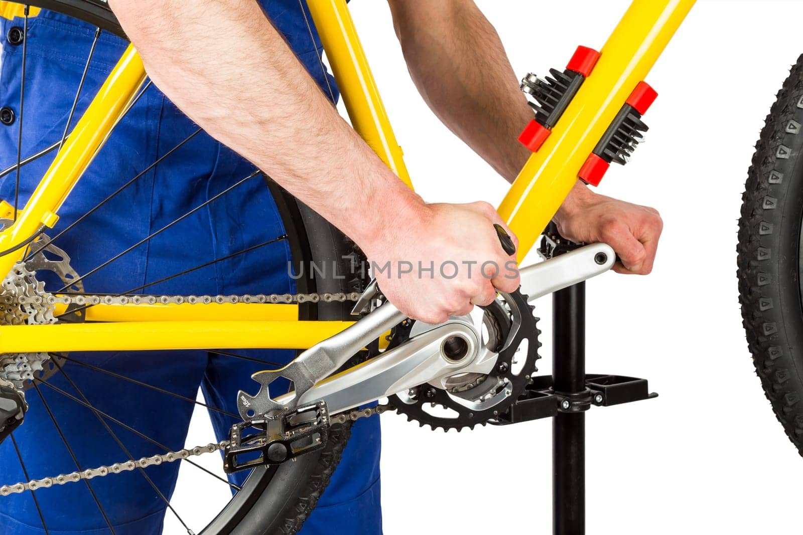 bicycle mechanic tightening pedal on mountain bike