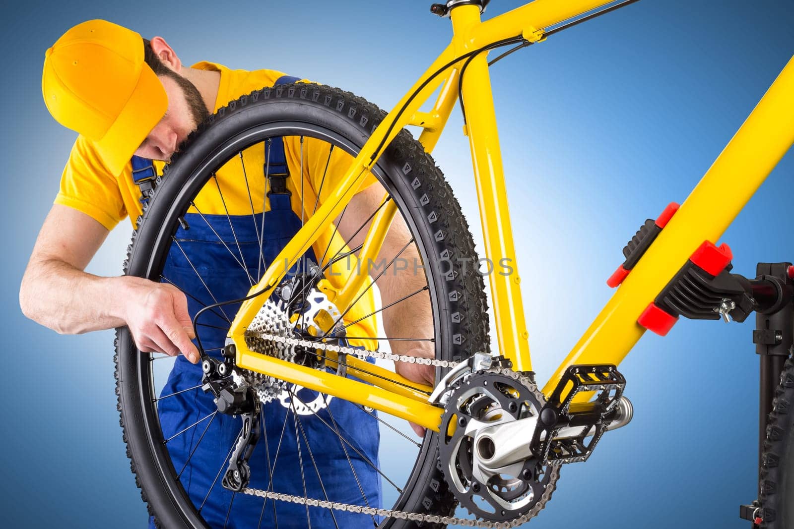 bicycle mechanic working on yellow mountain bike