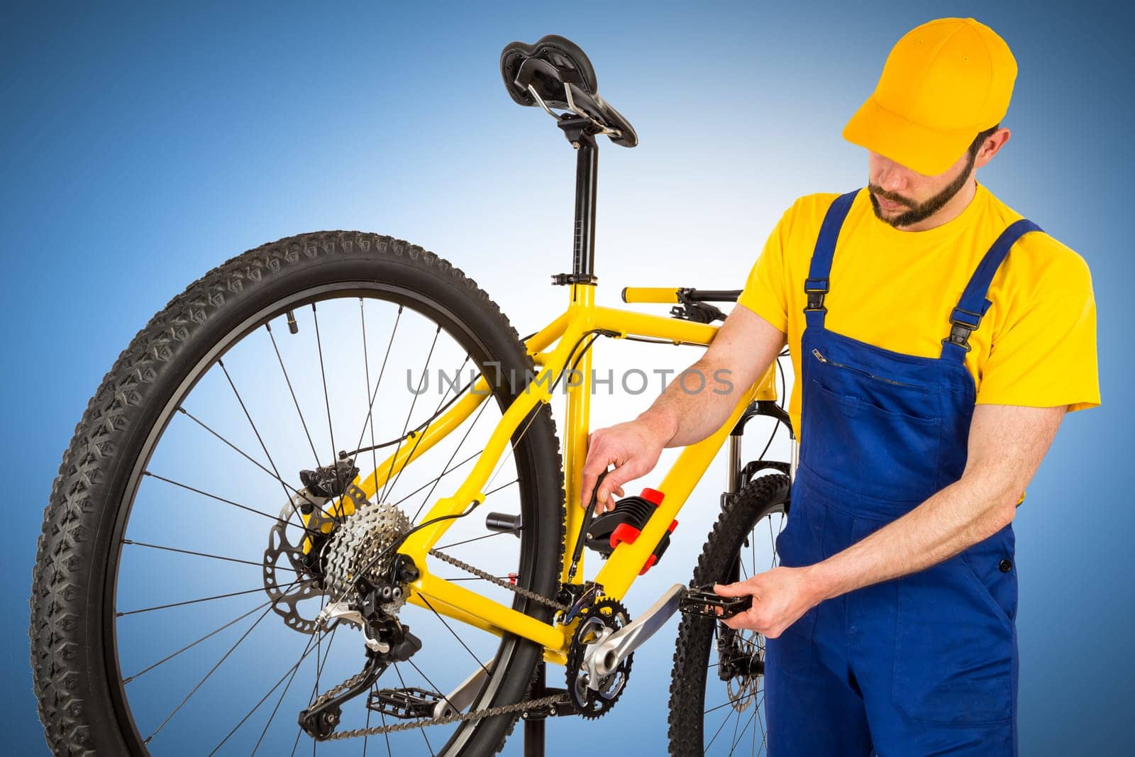 bicycle mechanic adjusting front derailleur mechanism on mountain bike