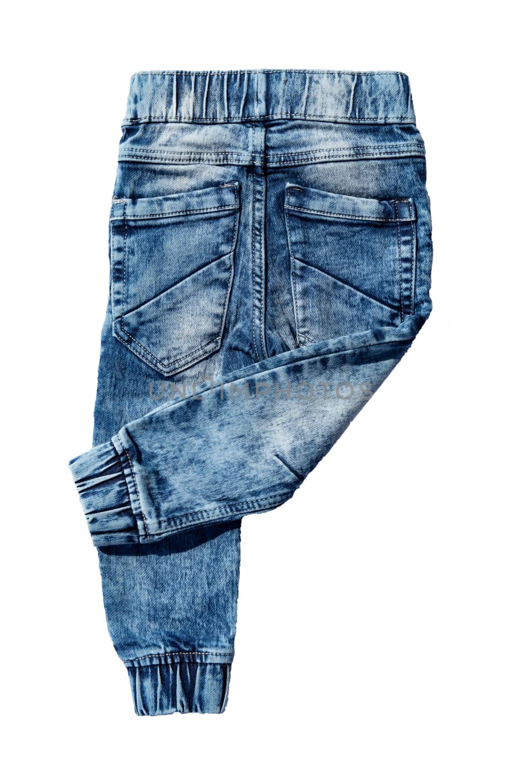 Blue jeans trousers isolated on white background. Fashionable jeans for child boy. Right trouser leg folded. Top view on back.