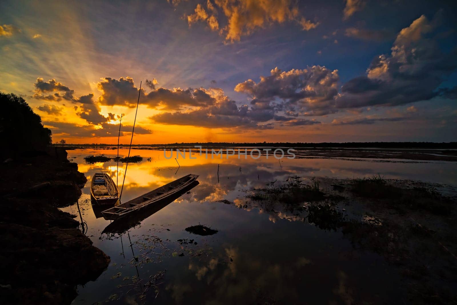 beautiful landscape with fishing boats and reflection of sunset
