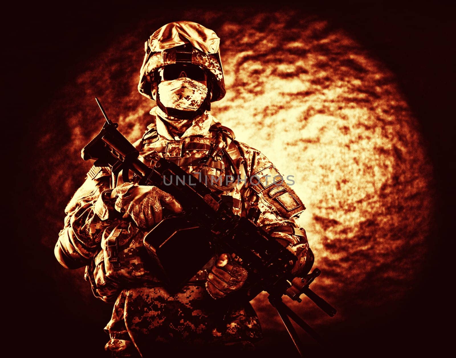 United States Marine Corps soldier in camouflage protective ammunition with hiding identity, armed with machine gun blue tone studio shot. Army infantry posing with weapon, spotlight in background