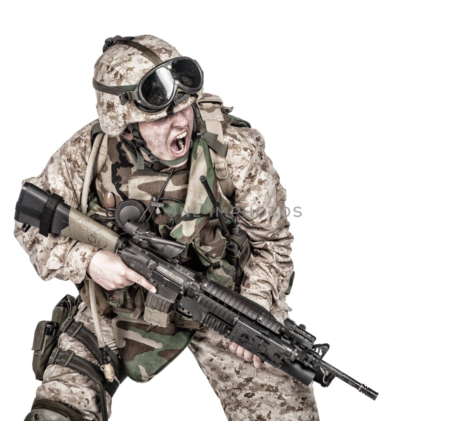 Studio shoot of modern infantry soldier, U.S. marine rifleman in combat uniform, helmet and body armor, screaming and crouching down with assault service rifle in hands isolated on white background