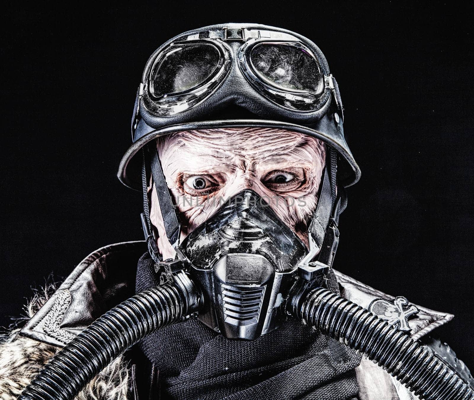 Ugly face of Futuristic nazi soldier in gas mask and steel helmet. Skin burned by atomic flame