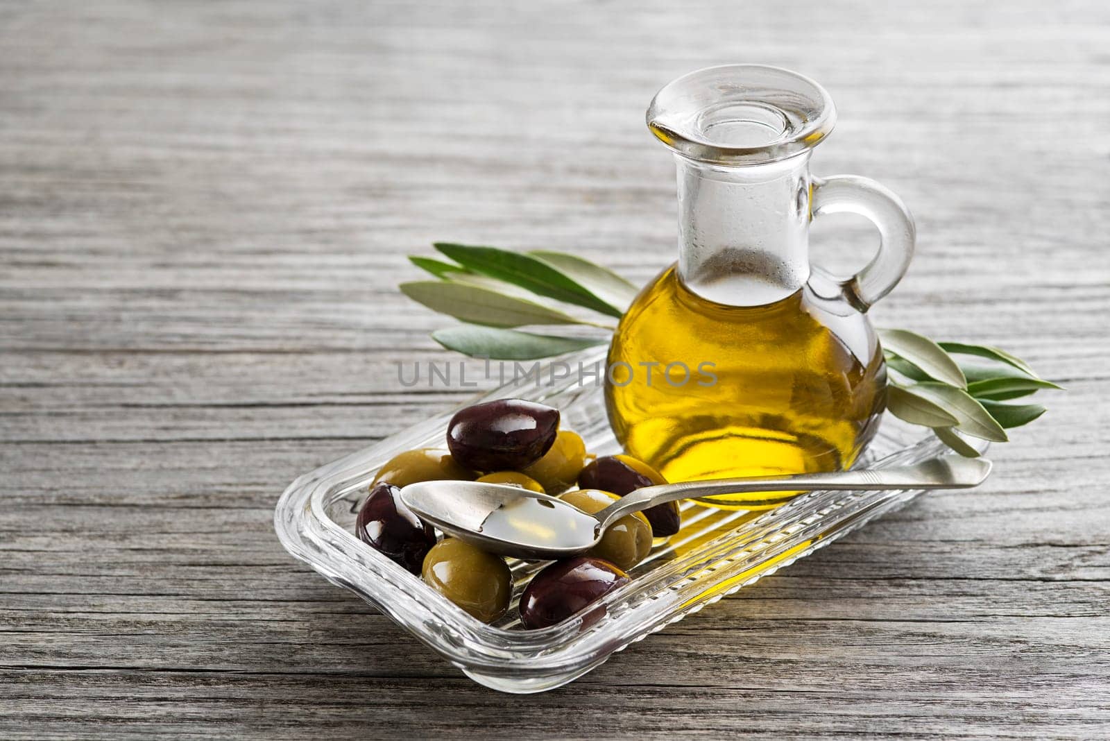 Bottle of Extra virgin healthy Olive oil with fresh olives close up